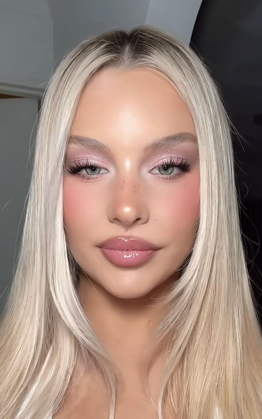 Woman with blonde hair and green eyes wearing soft pink prom makeup