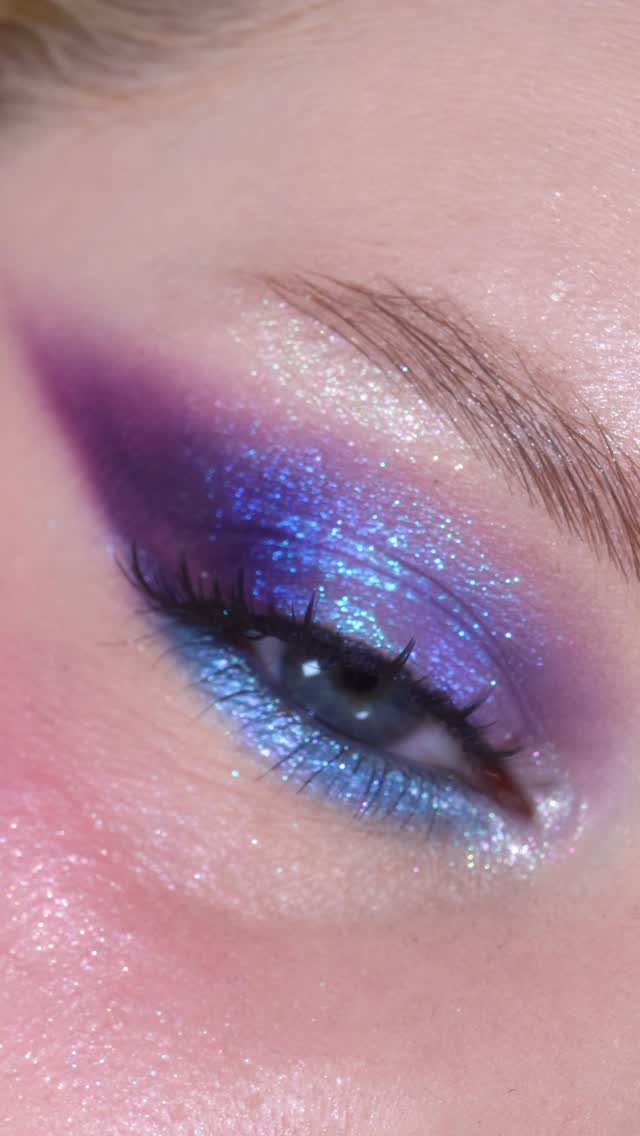 Blue eye with shimmering purple and blue glitter eyeshadow and purple wing.
