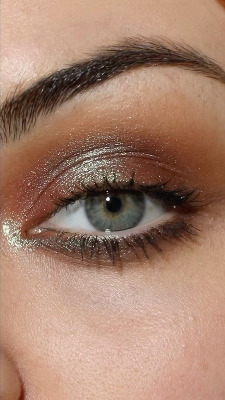Eye with gold shimmering halo eyeshadow and brown tones on fair skin