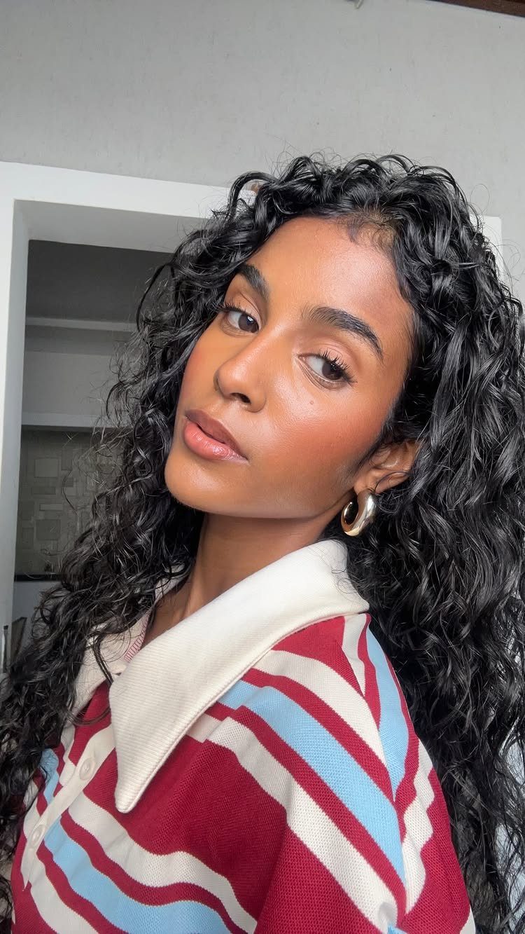 Woman with curly black hair and brown eyes wearing natural earth-toned makeup