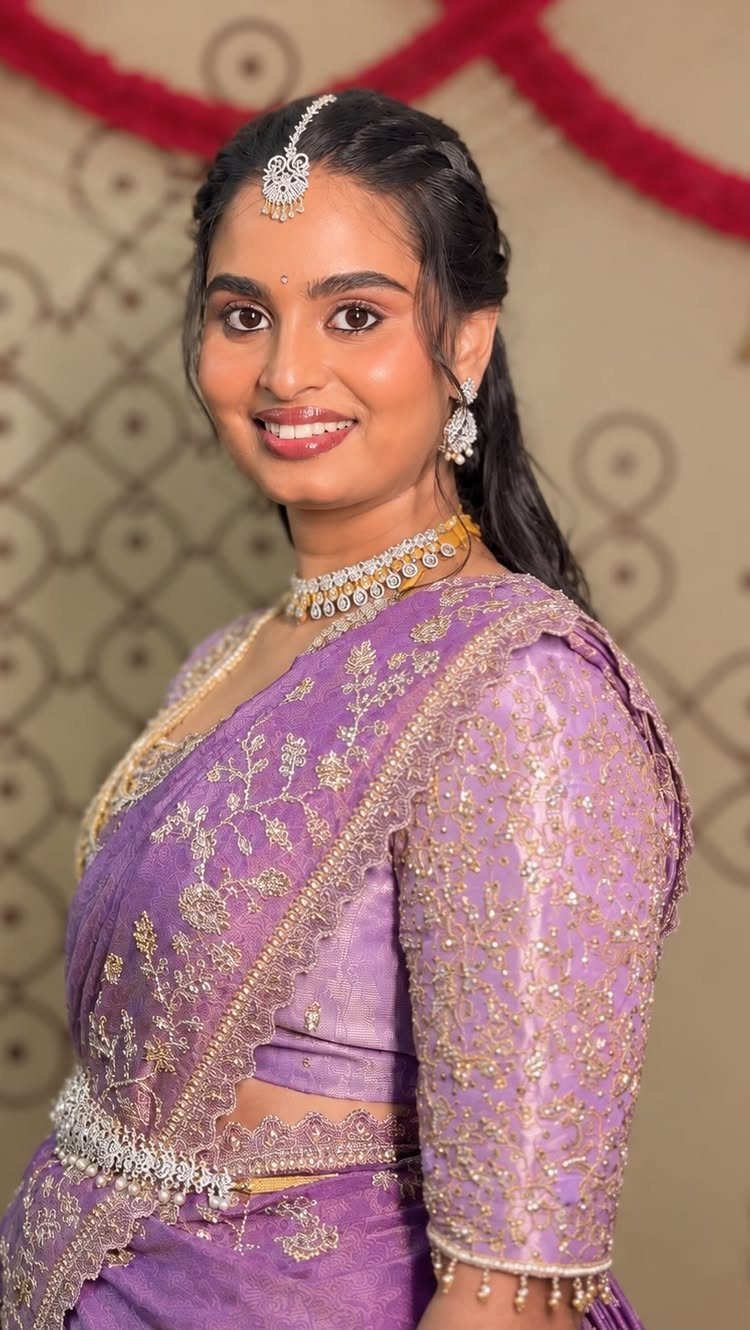 Woman in purple saree with soft glam makeup and traditional Indian jewelry