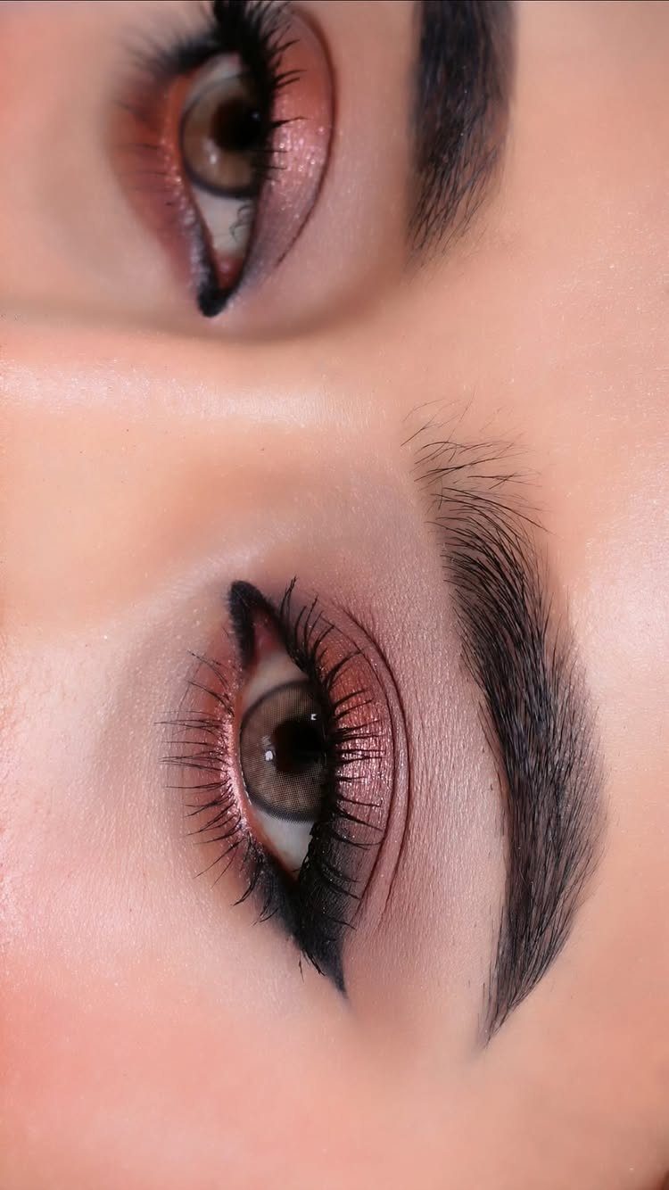 Eyes with shimmering rose-gold eyeshadow, winged black eyeliner, and defined dark eyebrows.