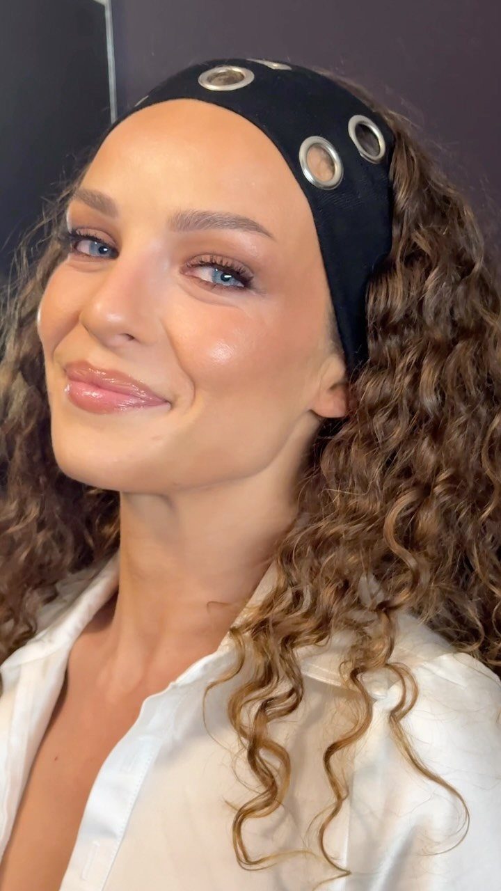 Soft Sultry Makeup Ideas: 10 Looks for Day and Night 5 Woman with curly hair wearing glossy pink lipstick and soft shimmering eye makeup.