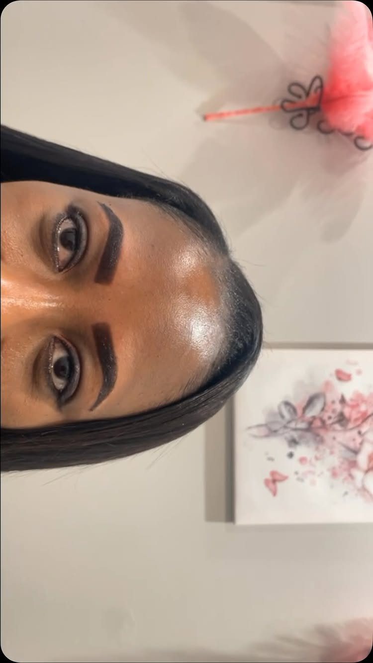 Woman with dark, precisely shaped and tinted eyebrows looking at the camera.