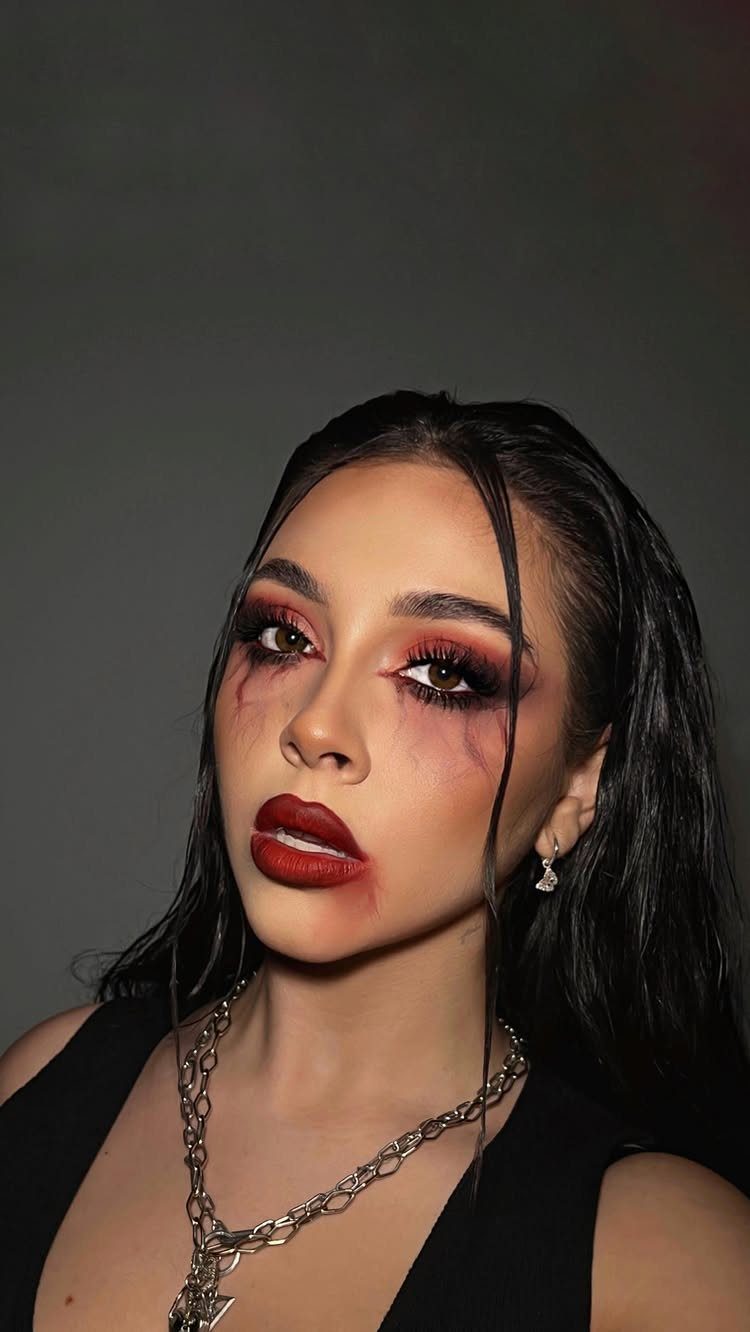Vampire Eye Makeup Ideas: 8 Looks for Halloween Night 7 Woman with red and black vampire eye makeup and blood-like streaks under eyes.