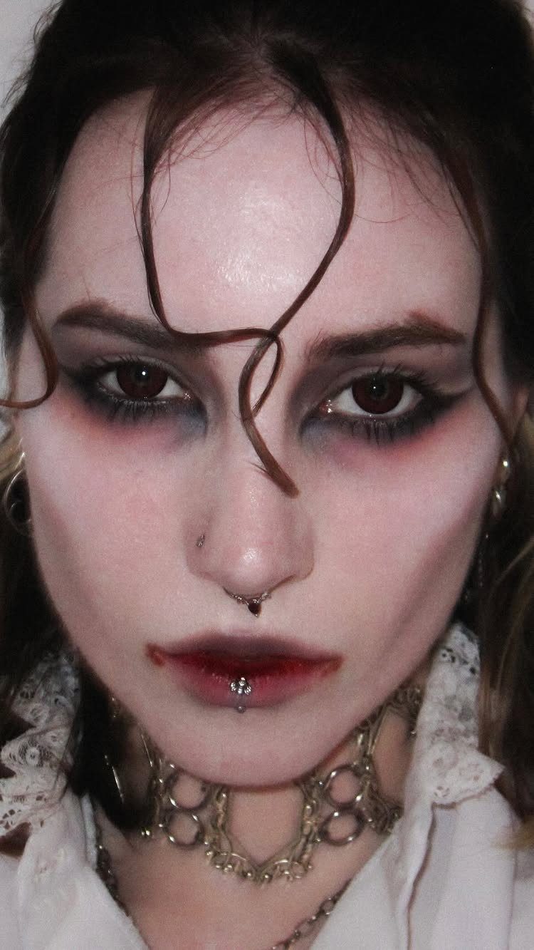 Vampire Eye Makeup Ideas: 8 Looks for Halloween Night 1 Person with plum and black vampire eye makeup, dark lips, and lace collar.