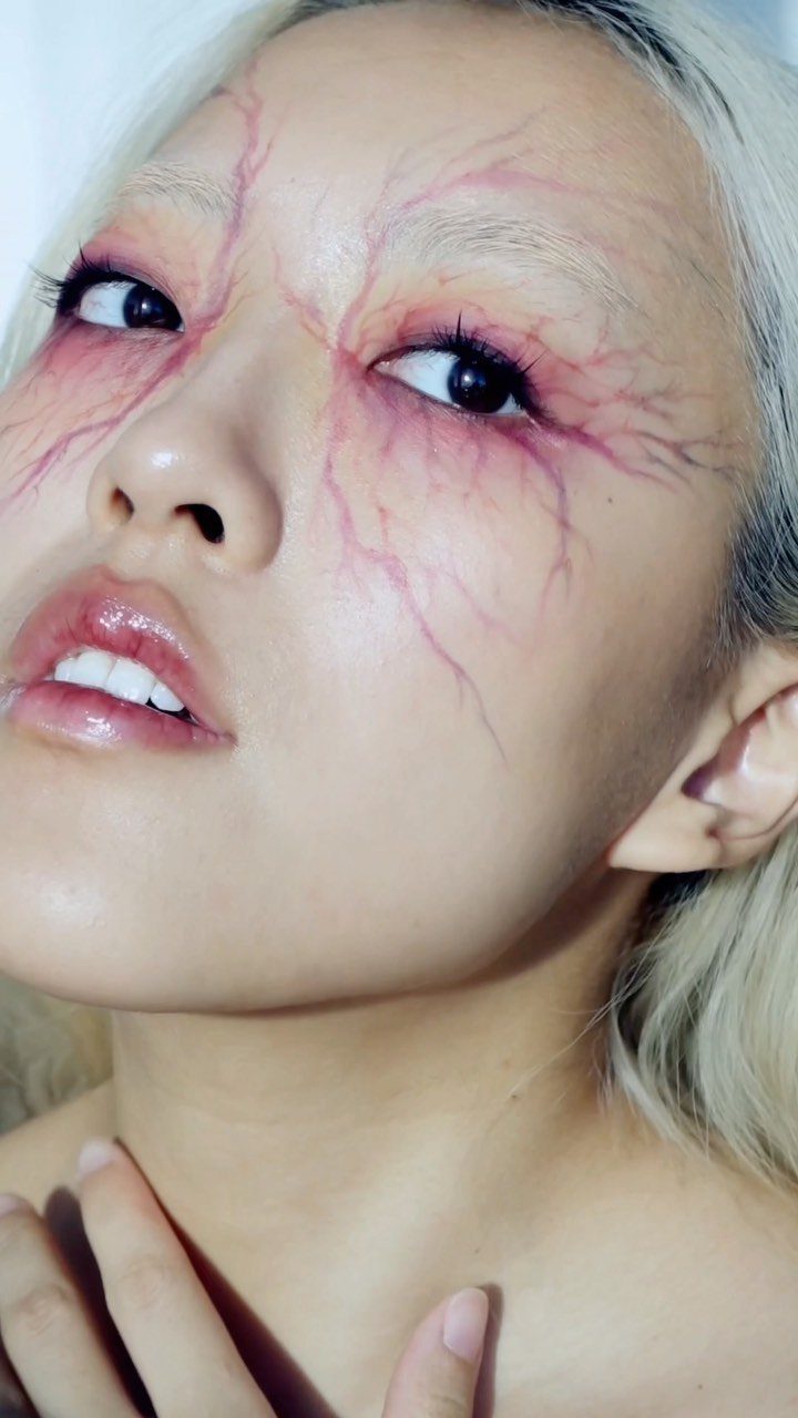Vampire Eye Makeup Ideas: 8 Looks for Halloween Night 6 Person with red vein makeup around eyes and glossy red lips.