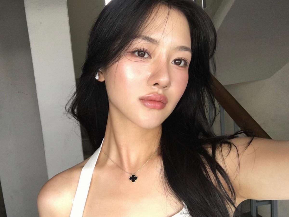 Warm Asian Makeup: 6 Peach, Coral and Red Ideas 1 Woman with glowing skin and peach-tinted highlighter on her cheeks and nose.