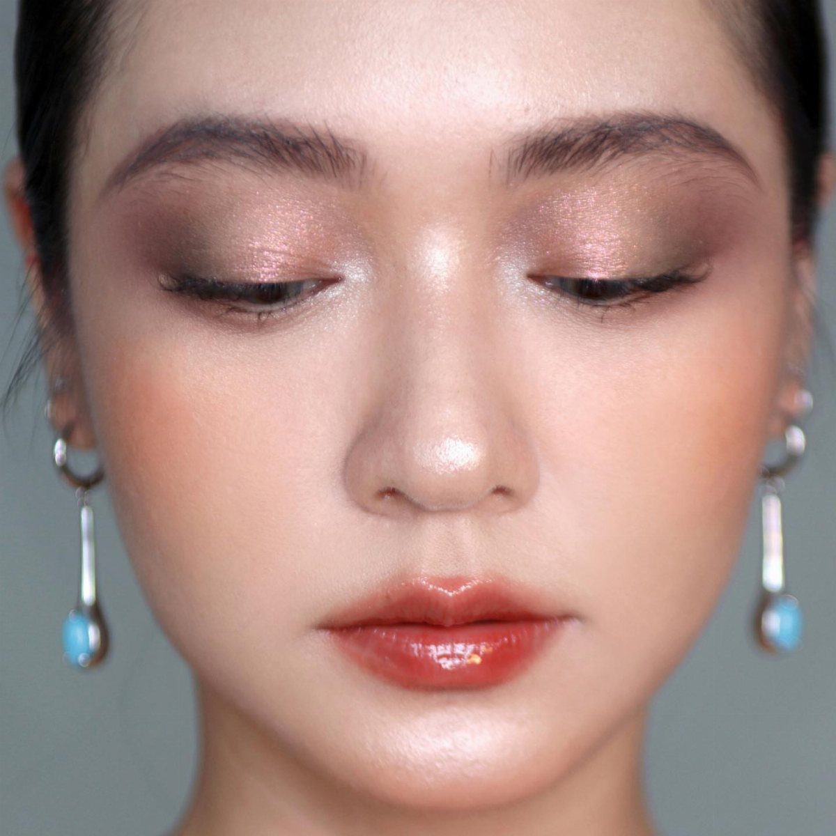 Warm Asian Makeup: 6 Peach, Coral and Red Ideas 2 Asian woman with shimmering bronze eyeshadow, peach blush, and glossy red lips.