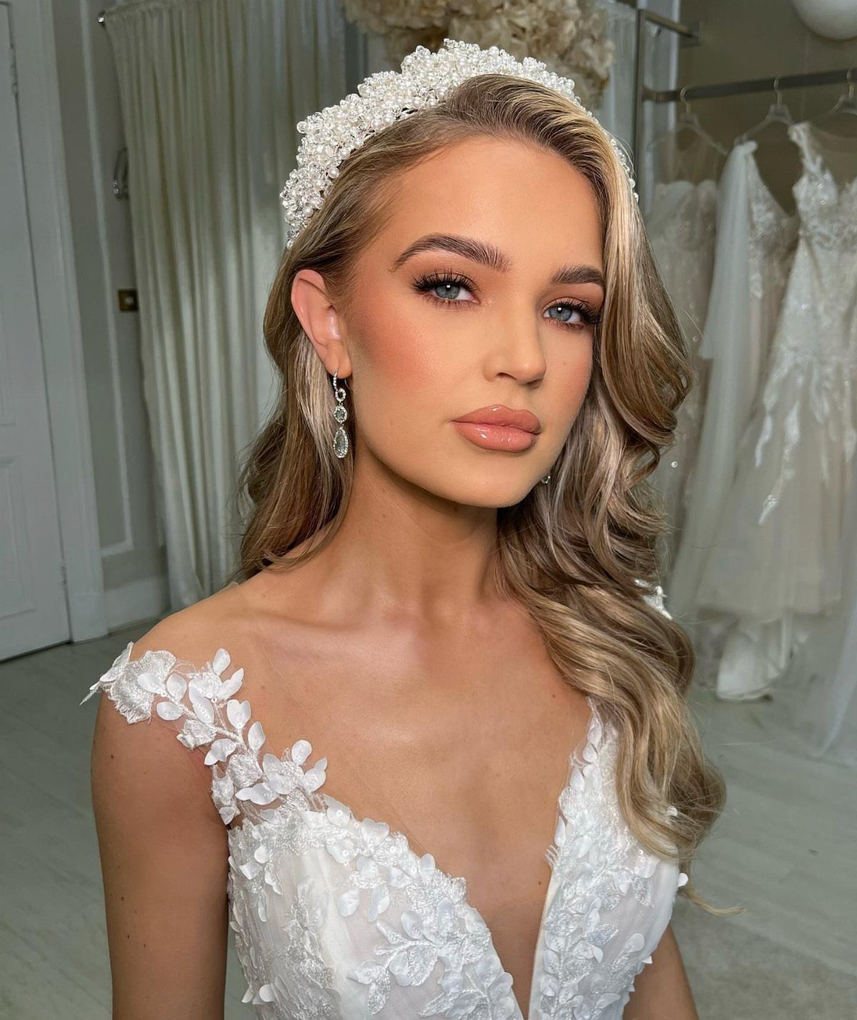 Bride with blue eyes wearing champagne shimmer eyeshadow and a white lace gown