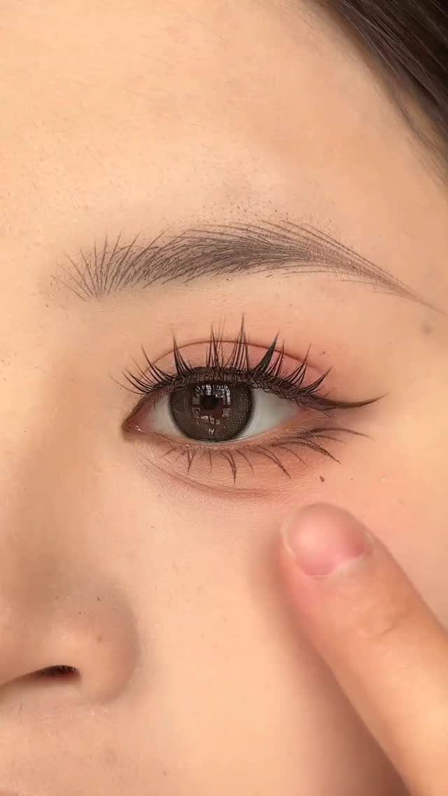 Close-up of an eye with spiky mascara and winged eyeliner in y2k style.