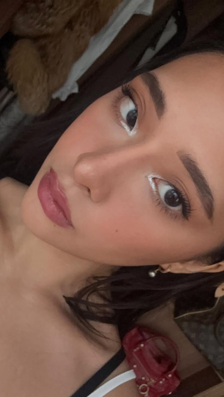 Woman with y2k style makeup featuring white eyeliner and mauve lipstick.